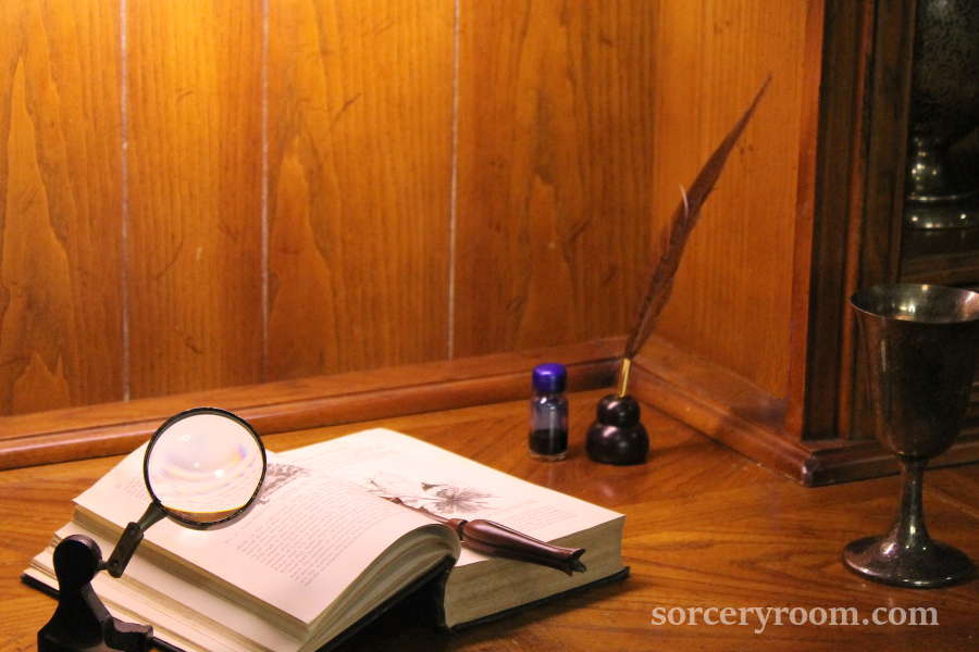 Book, quill and ink, magnifying glass