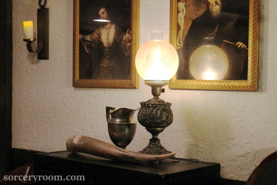 Metal lamp with a glass shade, silver goblet, bull horn, paintings in gold frames