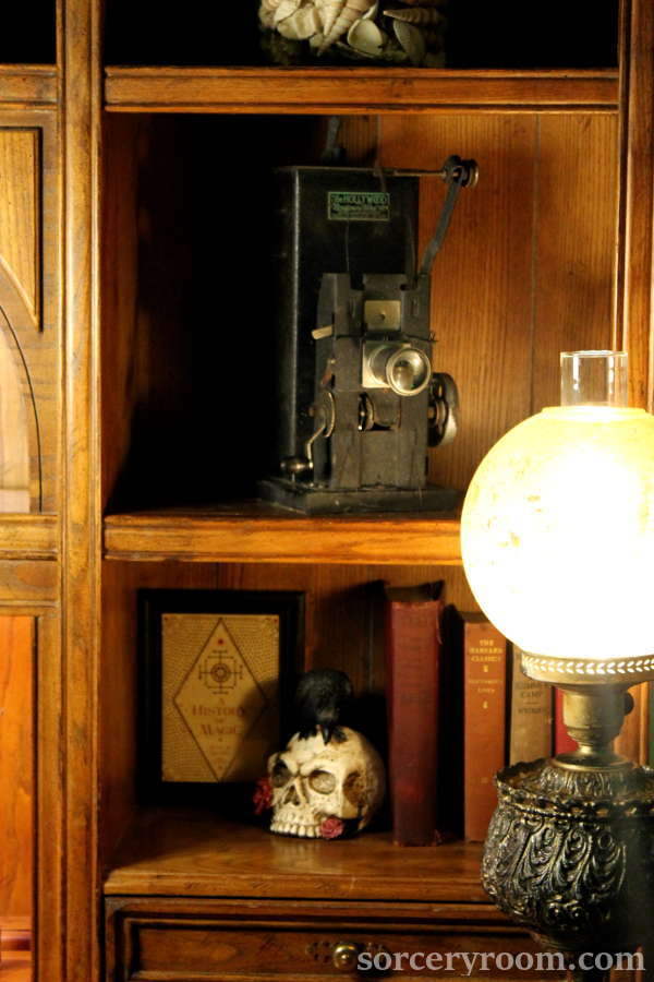 Metal lamp with a glass shade, books, skull, antique projector