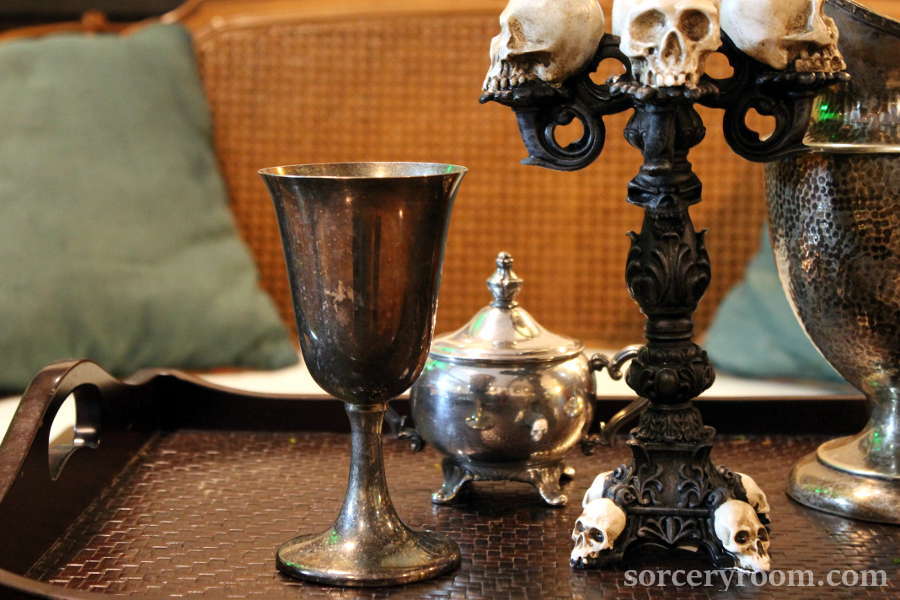 silver goblet, silver sugar bowl, skull candelabra on a tray