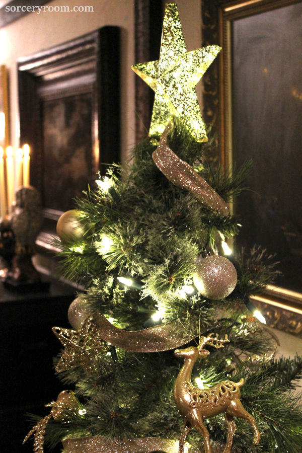 Harry Potter Christmas tree - closeup of the top section of the tree and decorations (golden star tree topper, golden globes, stars, birds, elk, and ribbon)