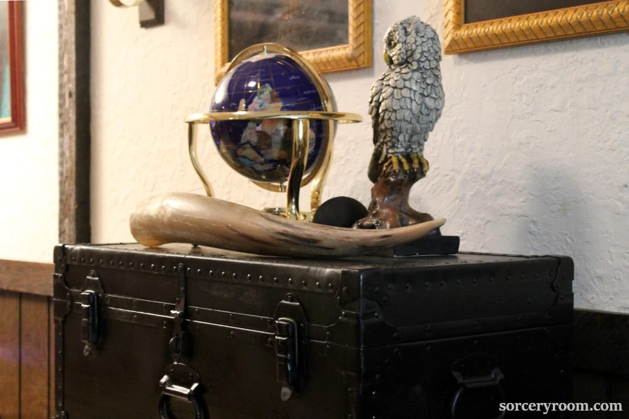 Harry Potter themed accessories: own figurine, world globe, large horn on a black steamer trunk