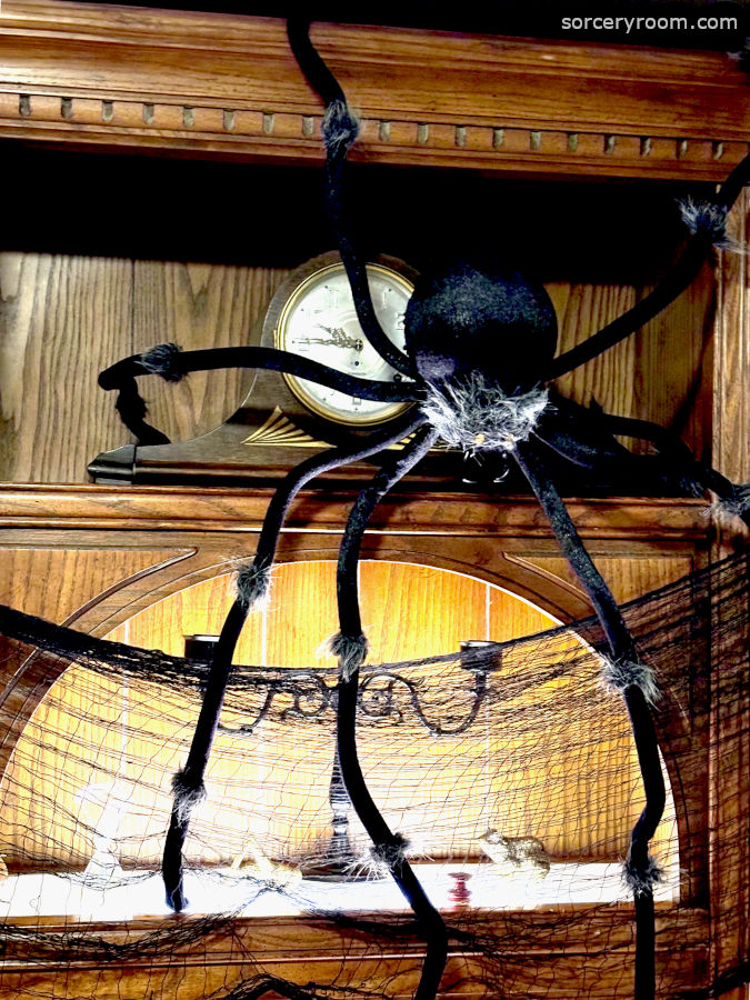 Harry Potter themed Halloween décor - a large decorative spider appears to be crawling down a sorcery inspired shelf